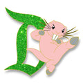 Rufus kicking beside a green glitter Signature D